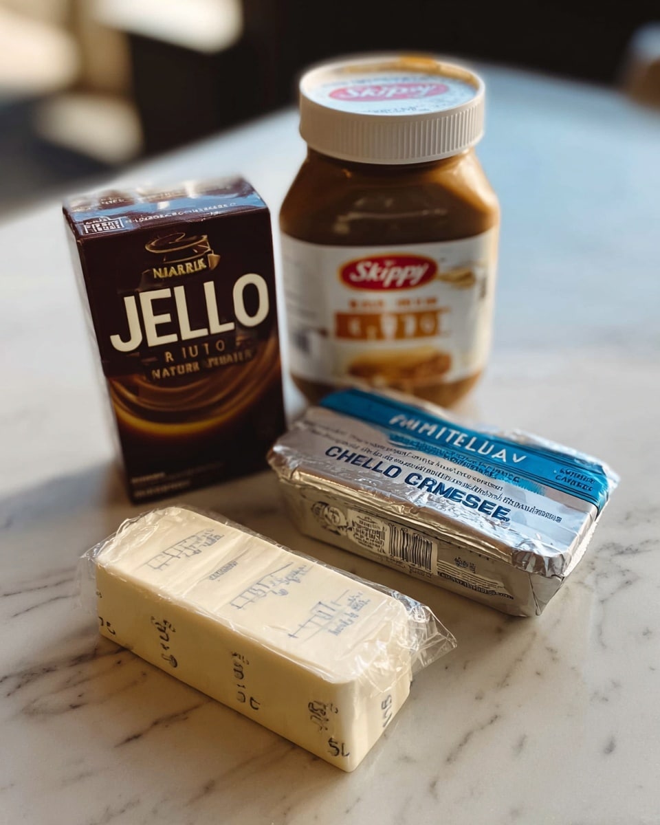 The image shows four cooking ingredients placed on a white marbled surface. There is a jar of Skippy Natural peanut butter with a brown lid, positioned upright and towards the back. To the left is a box of Jell-O chocolate pudding, standing upright. In front, there are two rectangular blocks wrapped in paper: one is unsalted butter with measuring marks on the wrapper, and the other is Philadelphia cream cheese in its original silver and blue packaging. The arrangement of the items is slightly angled with soft natural light coming from the background. Photo taken with an iphone --ar 4:5 --v 7