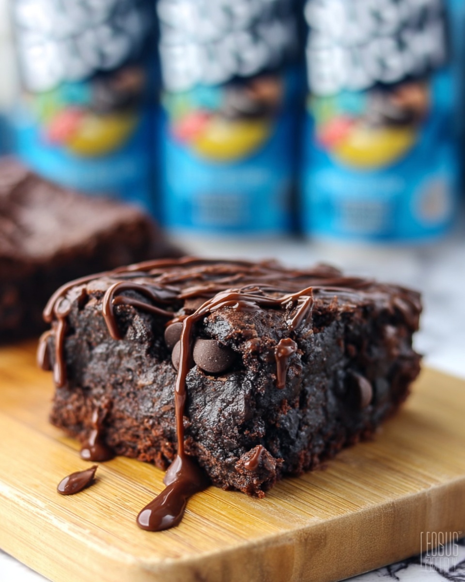 A single thick, dark brown brownie with a rough, cracked top layer sits on a light wood board. The brownie has a dense texture with visible chunks inside, and it is topped with smooth, shiny chocolate drizzles that run in thin lines across the surface and drip slightly over the edges. In the blurred background, two blue cans with colorful labels are visible, placed on a white marbled surface. Photo taken with an iphone --ar 4:5 --v 7