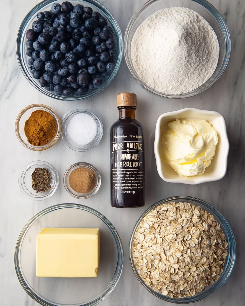 The image shows an arrangement of baking ingredients neatly placed on a white marbled surface. Starting from the top left, there is a large clear glass bowl filled with dark blue blueberries, next to it on the right is a similar sized bowl full of white granulated sugar. Below the sugar is a smaller clear glass bowl filled with white flour. Beside the flour to the far right, a bright yellow lemon is placed. On the bottom right quadrant, a block of pale yellow butter lies horizontally. Just above the butter is a small white bowl containing a white creamy substance, likely cream cheese. Near the center, a brown glass bottle labeled