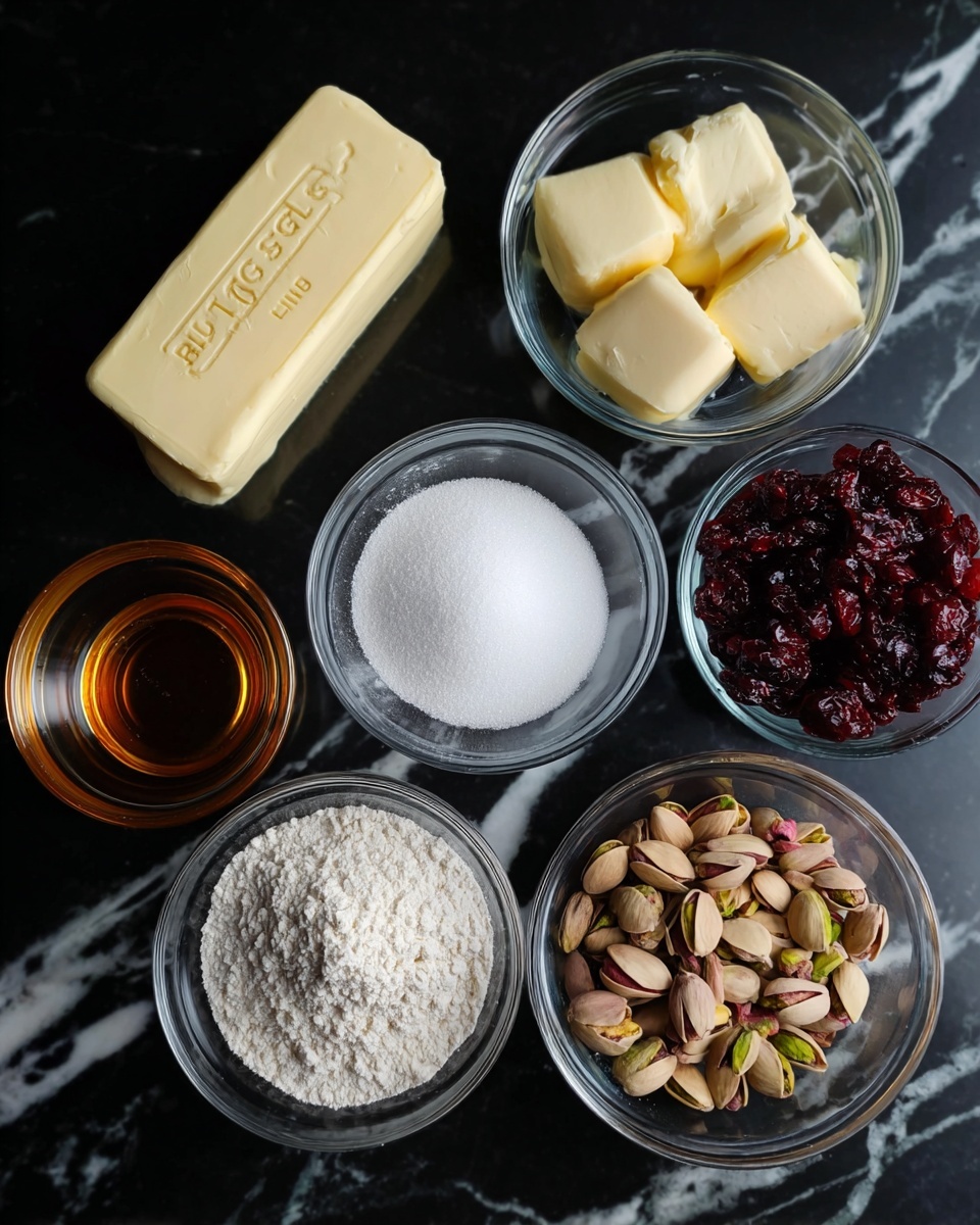 Seven clear glass bowls are arranged closely on a black surface with white marbled texture. One bowl holds a rectangular stick of pale yellow butter with
