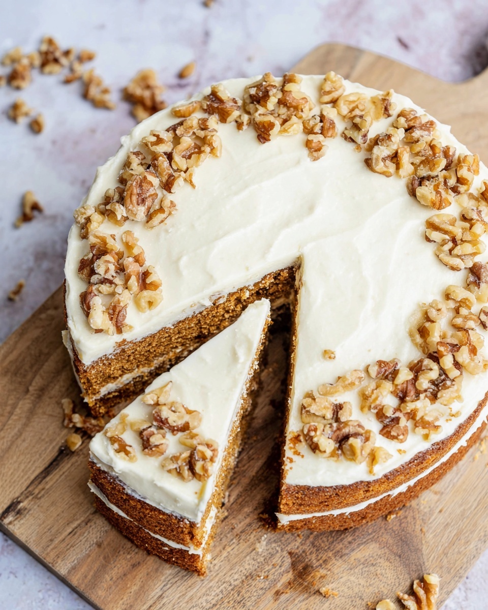 A round cake with two visible layers of light brown sponge, each separated by a thick layer of creamy white frosting. The top layer is fully covered with smooth white frosting, decorated with scattered chunky pieces of brown walnuts mainly around the edges. Two slices are cut and slightly separated from the cake, showing the texture of the sponge and the thick frosting on top and between the layers. The cake sits on a wooden cutting board on a white marbled surface, with a few walnut pieces scattered nearby. Photo taken with an iphone --ar 4:5 --v 7