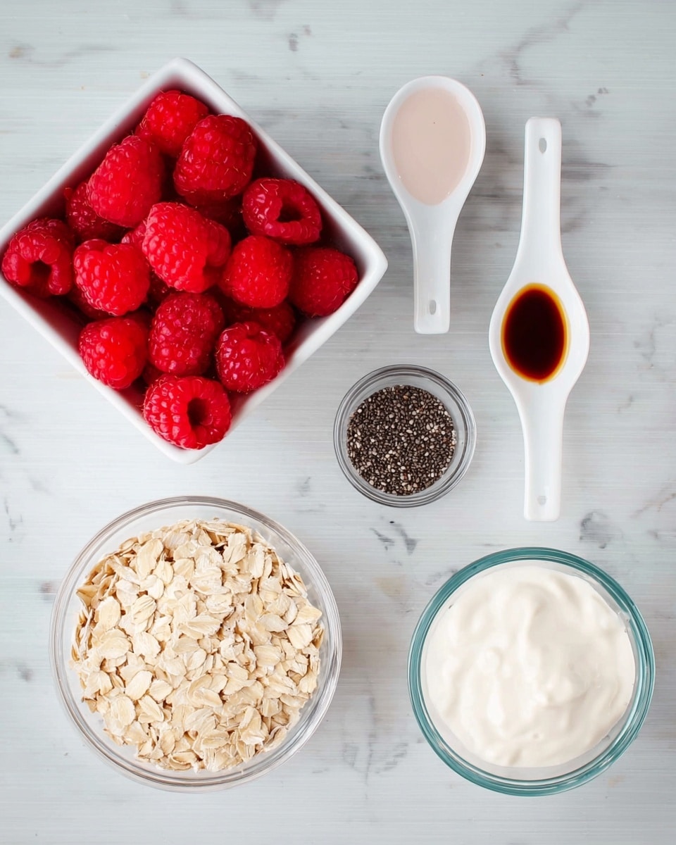 A square white container filled with bright red raspberries is placed on the top left over a white marbled surface. To the right, there are three white spoons arranged vertically with different ingredients: top spoon has dark amber vanilla extract, middle spoon holds white powder, and the bottom spoon contains black chia seeds. On the left side below the raspberries, there is a small clear glass bowl filled with light beige rolled oats. On the right side, two small clear glass bowls are stacked vertically; the top bowl contains pale pink almond milk, and the bottom bowl is filled with thick white yogurt. photo taken with an iphone --ar 4:5 --v 7