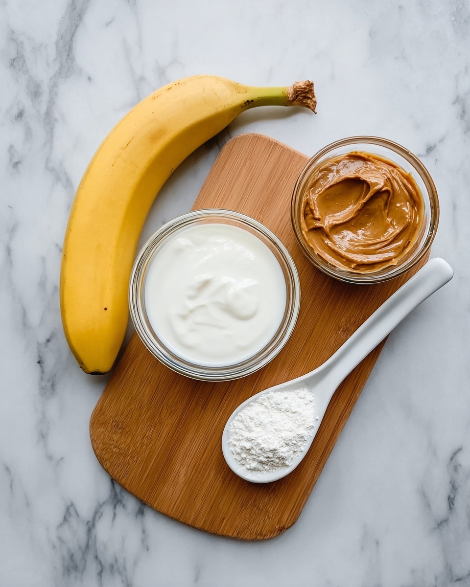 A ripe yellow banana lies on a white marbled surface next to a small white ceramic spoon filled with a smooth brown peanut butter. Below the banana, there is a wooden board holding two clear glass bowls, one filled with thick white yogurt and the other with white milk. On the wooden board between the two glass bowls sits another white ceramic spoon filled with fine white powder. The scene is well lit and shows a clean, simple arrangement from above. Photo taken with an iphone --ar 4:5 --v 7