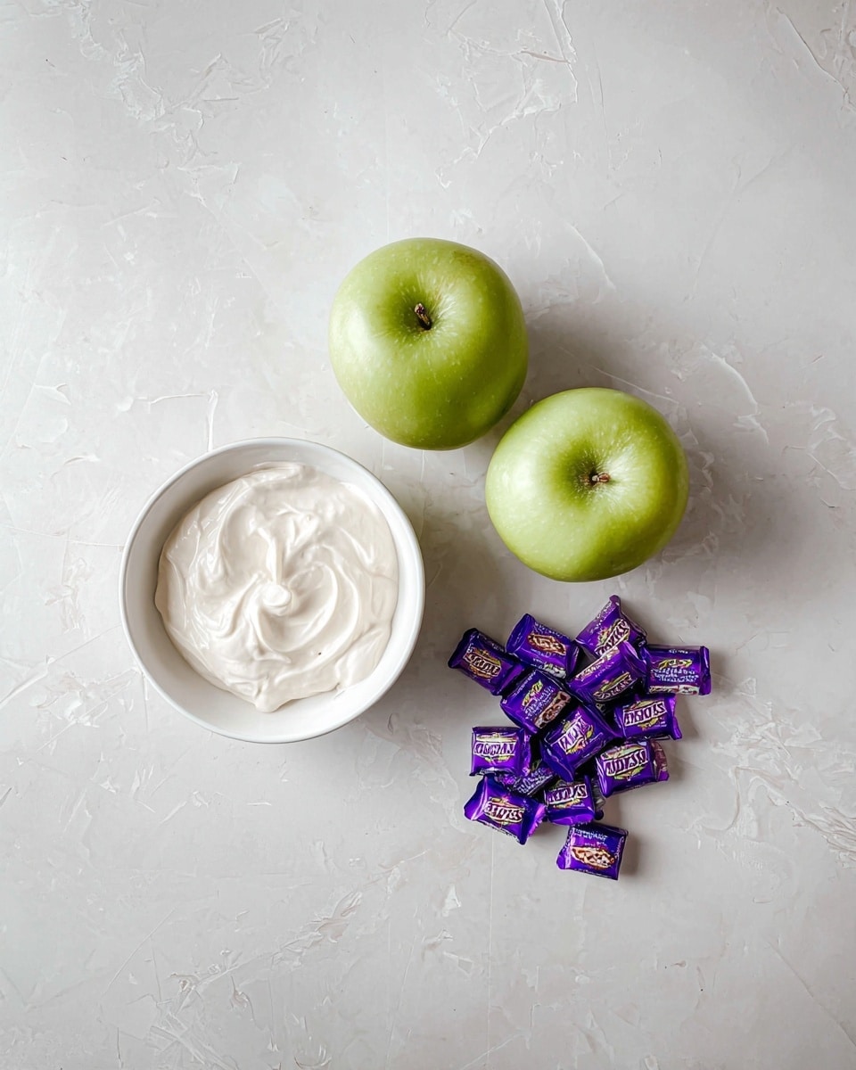 The image shows three green apples placed close together on a white marbled surface. To the left of the apples is a round white bowl filled with white creamy substance with a smooth texture and slight swirls on top. To the right of the apples is a small pile of purple-wrapped Snickers mini chocolates, scattered casually. The whole setup is on a white marbled surface that has faint gray veining and light scratches, giving a clean and simple look. photo taken with an iphone --ar 4:5 --v 7