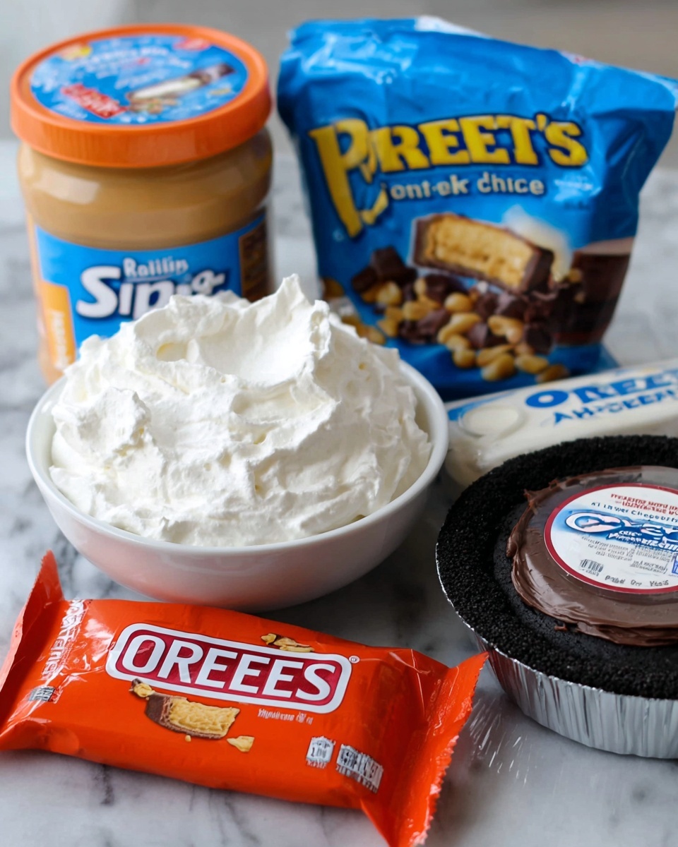The image shows a close-up of several dessert ingredients arranged neatly on a white marbled surface. In the foreground, there is a white bowl filled with fluffy white whipped cream. Behind it and to the right, there is a round Oreo pie crust with a dark chocolate color, its label visible in the center. Next to the crust is a block of Philadelphia cream cheese in its blue and white packaging. Behind these items are three large bags: a jar of creamy Skippy peanut butter with a blue label on the left, a bright orange bag of Dark Reese’s miniature peanut butter cups in the center, and a bag of sugar with a red and blue label on the right. The overall setup is bright and well-lit, showing all textures clearly. Photo taken with an iphone --ar 4:5 --v 7