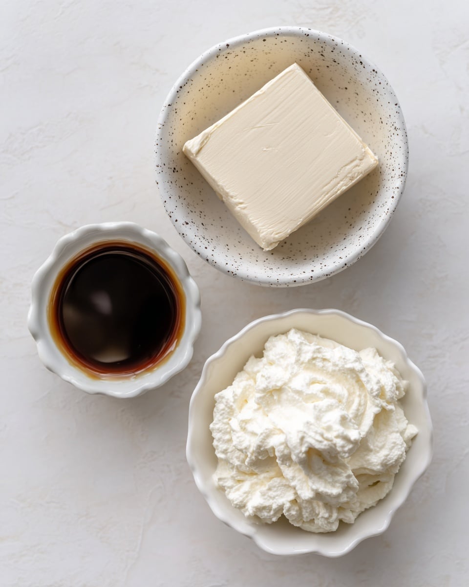 Three small bowls sit on a white marbled surface. The top bowl is white with black speckles and holds a thick, off-white block of cream cheese with a smooth texture. Below it to the right is a plain white bowl filled with a fluffy, white yogurt that has soft peaks and a creamy look. Below to the left is a white bowl with a scalloped edge texture holding a dark, glossy brown liquid, likely a syrup or sauce, reflecting light slightly. The bowls are spaced with some distance between them, arranged in a loose triangular shape. photo taken with an iphone --ar 4:5 --v 7