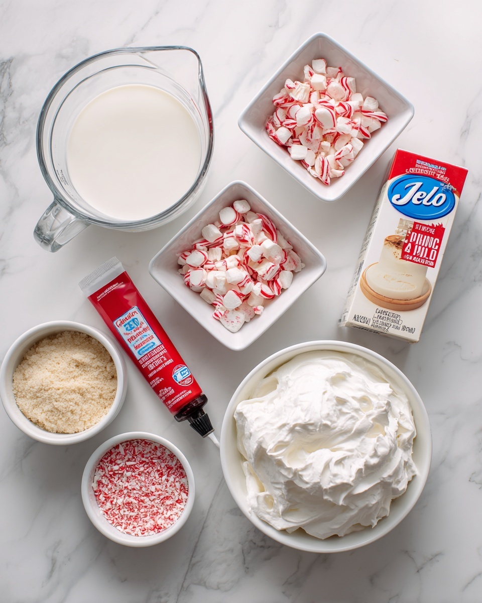 A white marbled surface holds various baking ingredients arranged neatly: at the top left, a clear glass measuring cup with white milk; next to it on the right, a small white square bowl filled with crushed peppermint candies that are white with red streaks; below the bowl, a tube of red gel food coloring lying horizontally; to the right of the tube, a box of JELL-O vanilla pudding mix with cream and red colors on the packaging; beneath the box, a small white bowl with red sugar sprinkles; at the bottom left under the milk, a white bowl full of light beige crushed vanilla Oreo cookie crumbs; next to it on the bottom right, a large white tub filled with fluffy white Cool Whip; and beside that, a small white bowl holding a dark brown bottle of peppermint extract. The setup is bright and clean with well-spaced items photo taken with an iphone --ar 4:5 --v 7