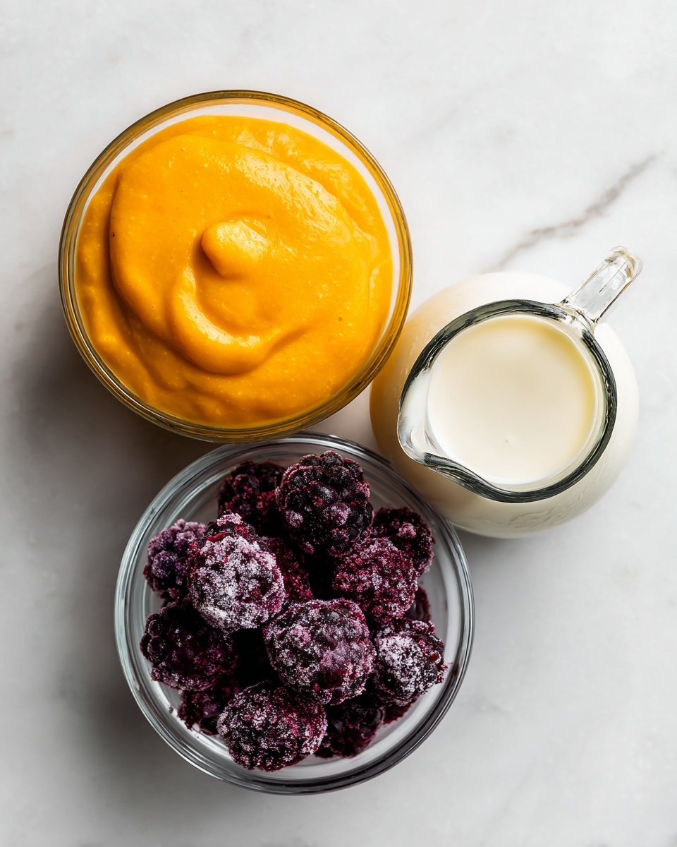 Three clear glass containers sit on a white marbled surface. On the left, a shallow round bowl holds a smooth, thick, bright orange puree. In the middle, a small glass jug with a handle is filled with white milk. On the right, another shallow round bowl contains dark purple frozen berries with a frosty texture. The arrangement is neat and the colors contrast well against the white marbled background photo taken with an iphone --ar 4:5 --v 7