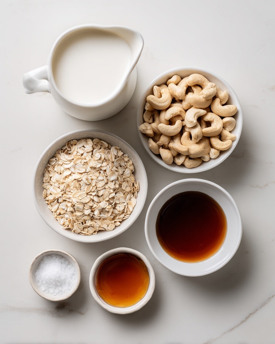 The image shows five small white bowls and a glass jug arranged on a white marbled surface. The top left jug is filled with white oat or other non-dairy milk. To its right, a bowl is full of pale beige raw cashews with smooth textures. Below the jug, there is a white bowl of light tan rolled oats with a rough texture. Next to it, a white bowl contains dark brown maple syrup that looks shiny and smooth. Below the maple syrup, a small white bowl holds a little mound of white fine salt. Finally, at the bottom left corner, a small white bowl has amber-colored vanilla with a slightly glossy surface. photo taken with an iphone --ar 4:5 --v 7