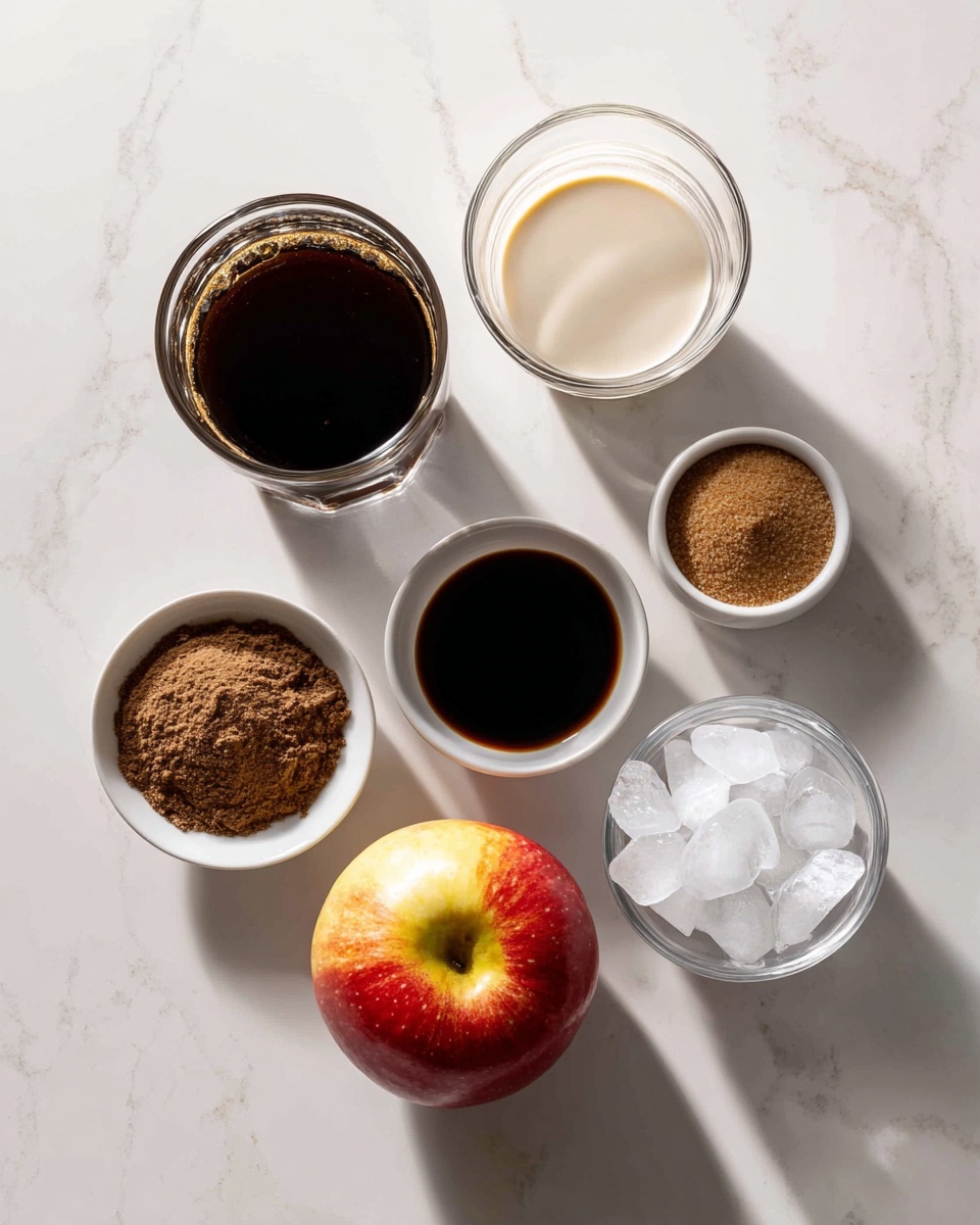 The image shows a group of ingredients arranged on a white marbled surface. There is a glass filled with dark brown coffee on the top left and a glass with light cream liquid below it. To the right of the coffee glass is a small white bowl with a dark brown liquid, below it is another small white bowl containing brown powder. Next to that bowl, there is a small white bowl with coarse brown sugar. To the right of the sugar bowl is a small glass with white liquid. Above it, a clear bowl holds crushed ice. At the center bottom of the image is a red and light yellow apple. The light and shadows give a clean, fresh look. photo taken with an iphone --ar 4:5 --v 7