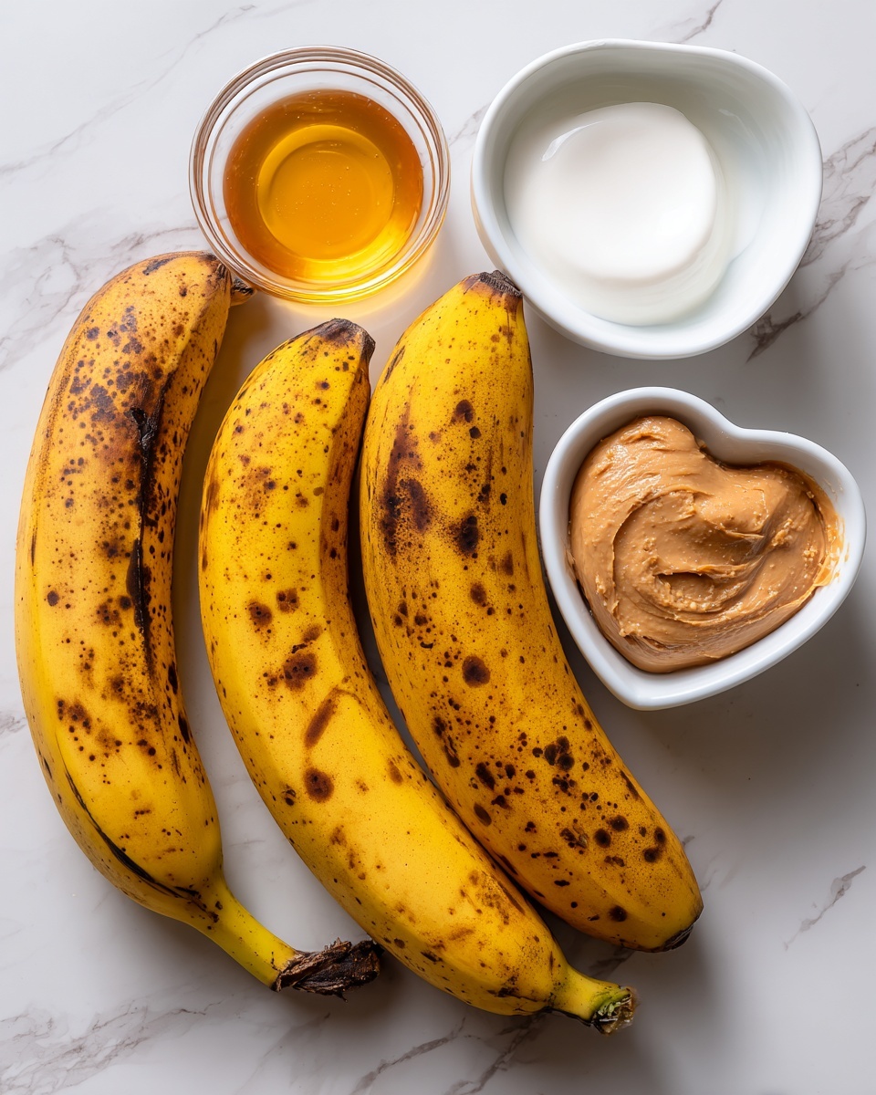 The image shows four ripe plantains with yellow skin and brown spots placed on a white marbled surface. Next to the plantains, there are three small white bowls: one round bowl filled with golden honey at the bottom left, another clear round bowl containing solid white coconut oil at the top right, and a heart-shaped bowl with light brown peanut butter at the bottom right. Each ingredient is clearly visible with distinct colors and textures. Photo taken with an iphone --ar 4:5 --v 7