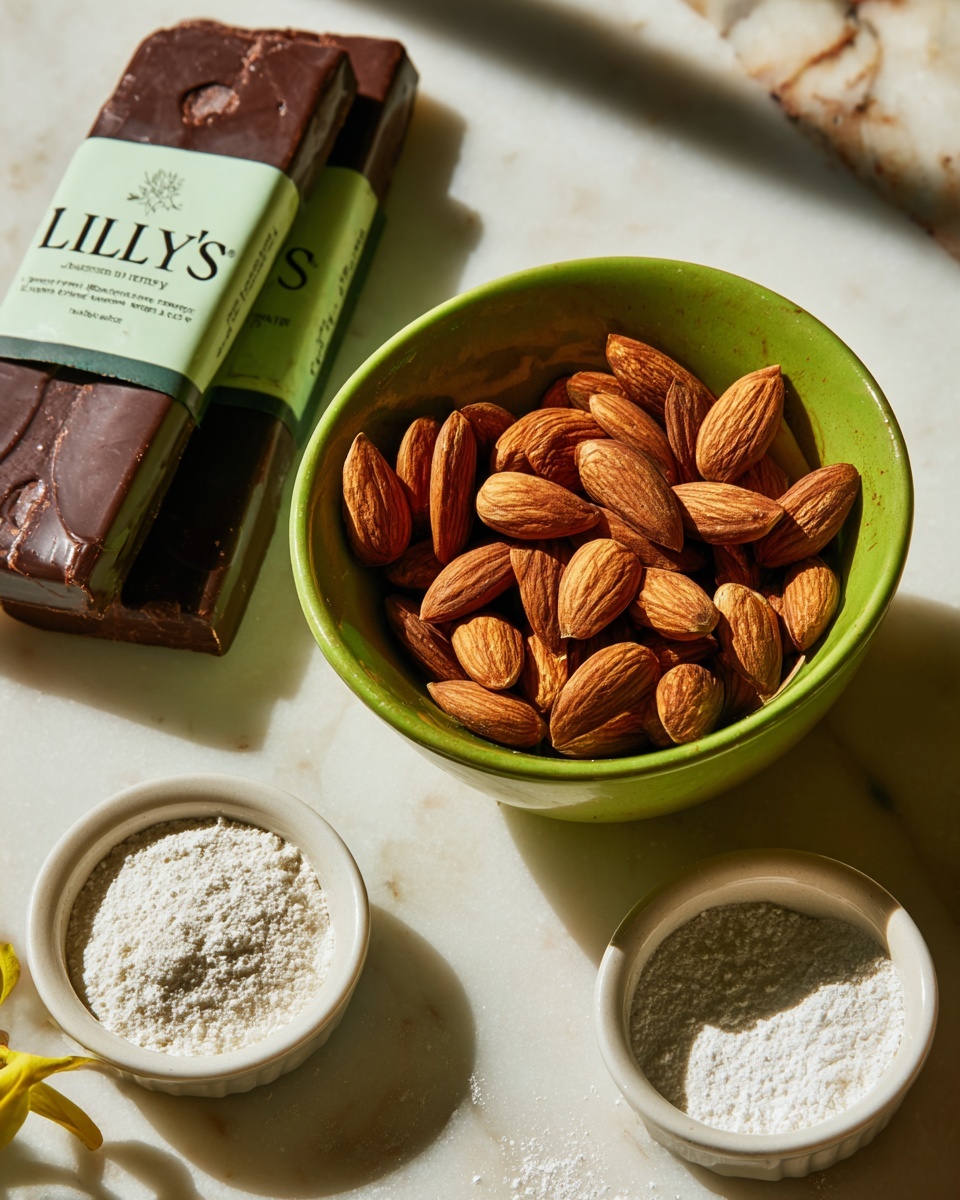A close-up of a bright green bowl filled with whole almonds sitting in front of two brown bars of dark chocolate baking bars with the label