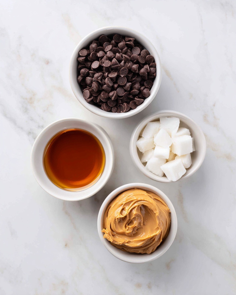 The image shows four white bowls placed on a white marbled surface. The largest bowl at the top is filled with dark brown chocolate chips. To the right of it, a smaller bowl contains white coconut oil chunks. Below, on the left side, there is a medium bowl filled with a dark amber liquid which looks like syrup. To the right of this bowl, another medium bowl holds smooth, light brown peanut butter with a creamy texture. photo taken with an iphone --ar 4:5 --v 7